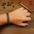 Geflochtenes Lederarmband ICE in Schwarz-Weiß auf Handgelenk – stilvolles Unisex-Accessoire für Business, Freizeit & festliche Anlässe.
